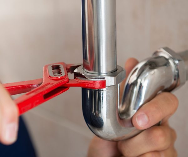 Closeup,Of,Plumber,Fixing,Pipe,With,Wrench